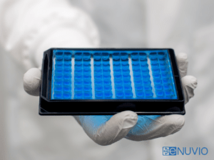 Scientist holding HTS-compatible microfluidic neuronal co-culture and compartmentalization screening plate OMEGA-96 microplate by eNUVIO. With eNUVIO logo