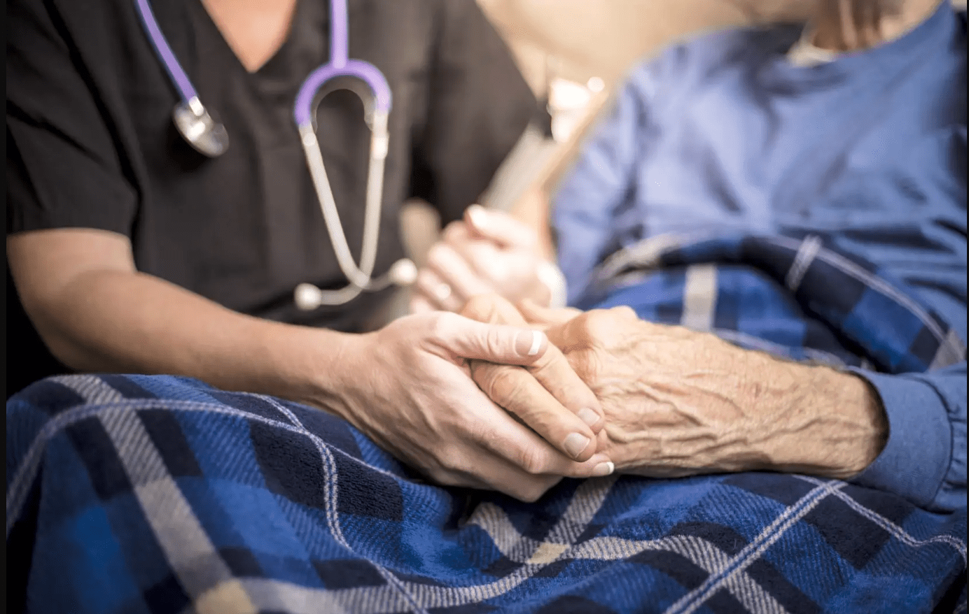 Photo of medical staff holding senior patient's hands